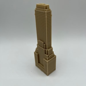 May include: A beige 3D printed model of a skyscraper with a detailed facade.