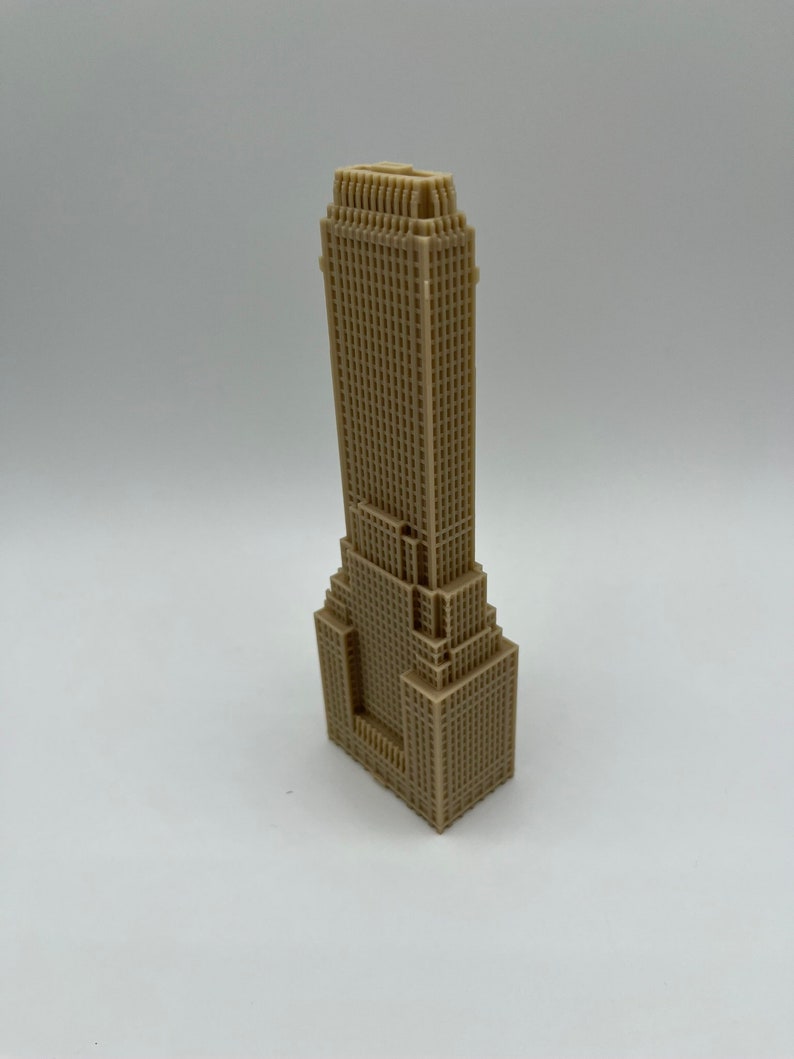 May include: A beige 3D printed model of a skyscraper with a detailed facade.