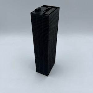 May include: A black miniature model of a skyscraper with a flat roof and many windows.