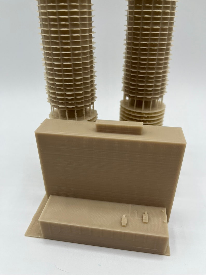 May include: A 3D printed model of a building with two towers and a rectangular base. The towers are made of stacked rings and the base has a flat top with two small details.