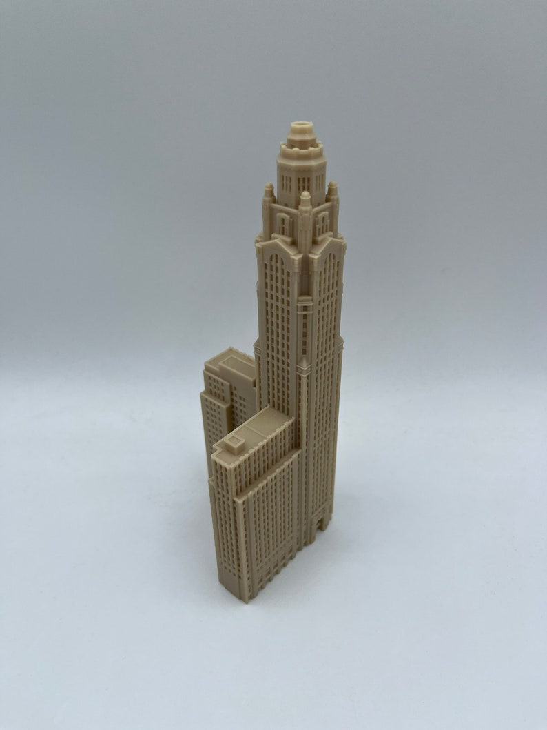 May include: A beige 3D printed model of a tall skyscraper with a domed roof and intricate details.