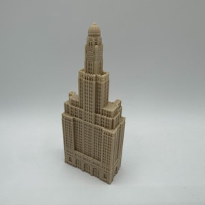 May include: A detailed model of a tall, beige building with a domed roof. The building has many windows and intricate details.