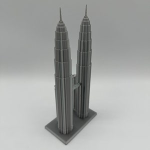 May include: A gray 3D printed model of the Petronas Towers, a famous landmark in Kuala Lumpur, Malaysia.