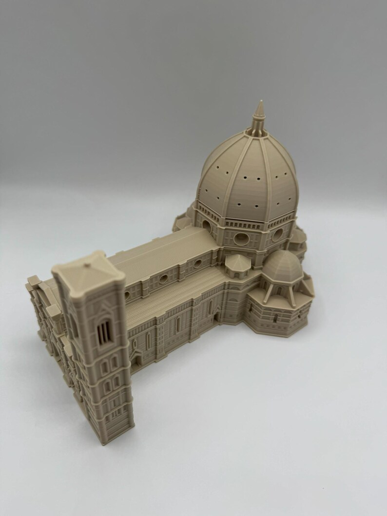 May include: A beige architectural model of a cathedral, featuring a large dome, rectangular structure, and a bell tower. The model is detailed with windows, arches, and other architectural elements. The model is a miniature replica of a famous building.