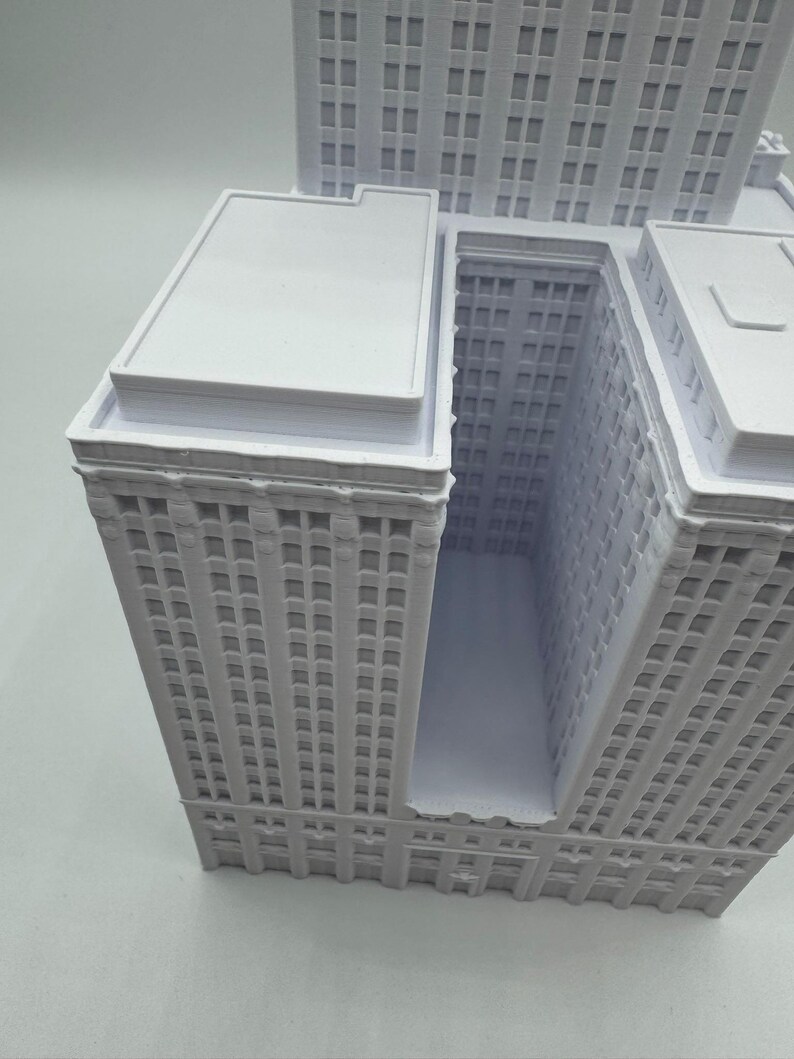 Puede incluir: Maqueta arquitect&oacute;nica blanca de una manzana de la ciudad, con varios rascacielos. El modelo tiene fachadas detalladas con numerosas ventanas y tejados planos. Los edificios est&aacute;n conectados, creando un dise&ntilde;o urbano &uacute;nico.