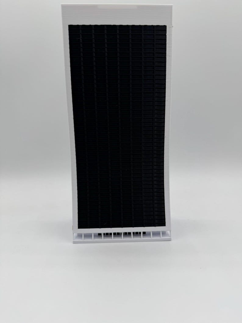 May include: A white model of a tall building with a black grid pattern on the front.