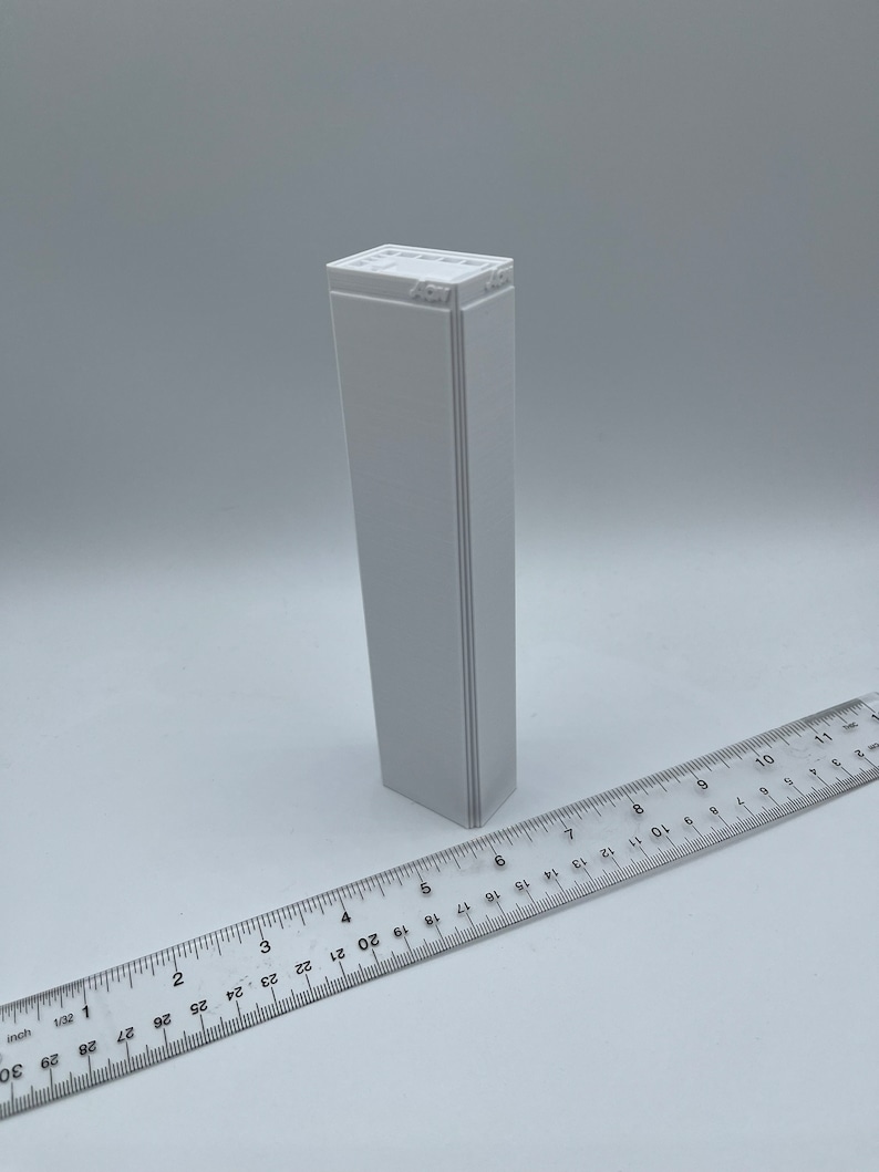 K&ouml;nnte beinhalten: Eine wei&szlig;e rechteckige Box mit dem Text "457" auf der Oberseite. Die Box ist etwa 15 cm hoch und 2,5 cm breit.