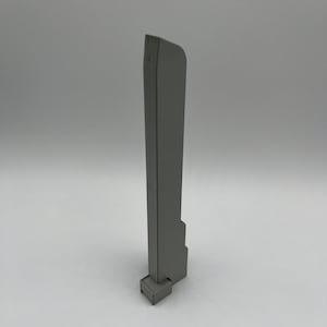 May include: A gray, 3D-printed architectural model of a skyscraper. The model has a rectangular base and a tall, slender body with a slightly curved top. The surface has a textured appearance.