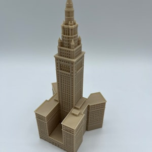 May include: A beige 3D printed model of the Terminal Tower in Cleveland, Ohio. The model is detailed and includes the tower's distinctive spire and surrounding buildings.