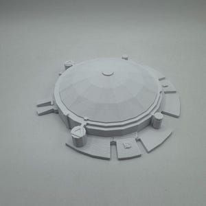 May include: A light gray, 3D-printed model of a domed structure. The model features a circular base with rectangular and triangular extensions, steps, and cylindrical pillars. The dome has a segmented, textured surface.