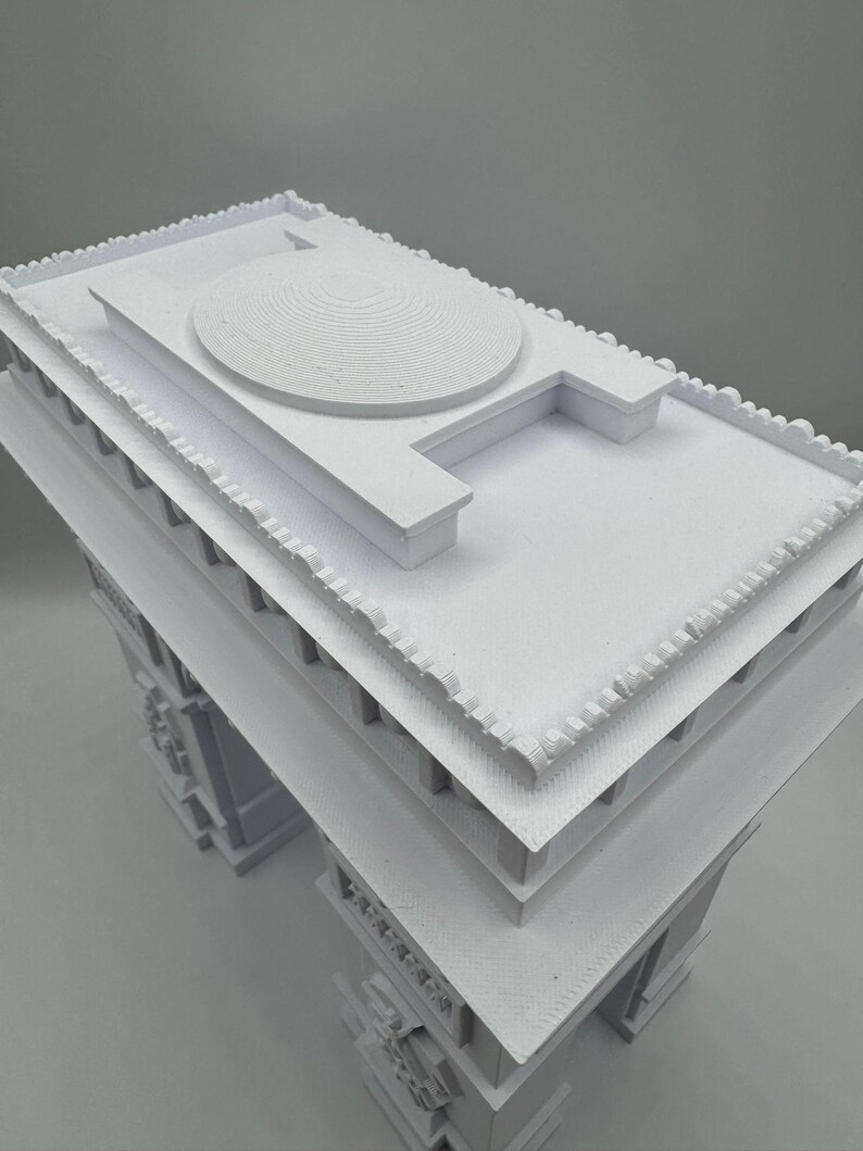 Może przedstawiać: Biały model architektoniczny budynku z kopulastym dachem i szczeg&oacute;łową fasadą. Model ma wiele warstw i skomplikowane wzory, prezentujące klasyczny styl. Konstrukcja wykonana jest z litego, nieprzezroczystego materiału.