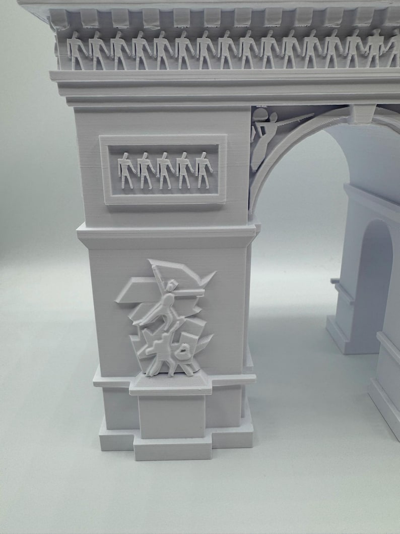 Może przedstawiać: Jasnoszara miniaturowa replika Łuku Triumfalnego. Model architektoniczny zawiera szczeg&oacute;łowe rzeźby postaci i rzeźby reliefowe. Łuk jest klasycznym pomnikiem.