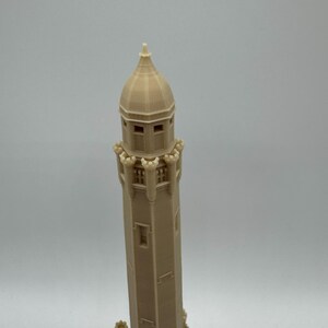 May include: A beige 3D-printed model of a tall tower with a domed top and multiple windows. The tower has decorative elements at the base and around the top, suggesting a historical or architectural theme.