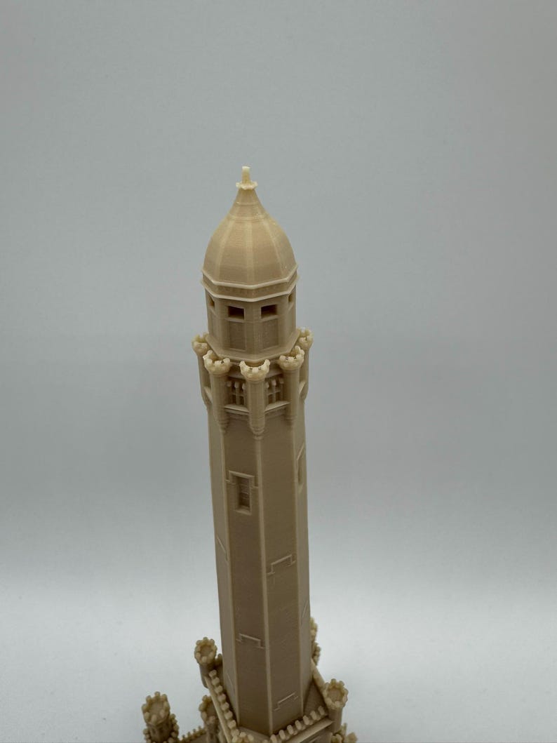 May include: A beige 3D-printed model of a tall tower with a domed top and multiple windows. The tower has decorative elements at the base and around the top, suggesting a historical or architectural theme.
