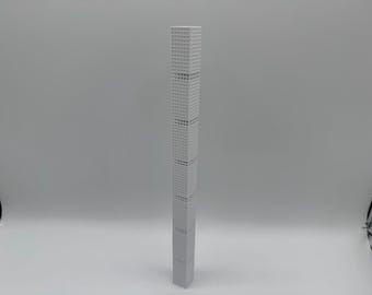 May include: A grey architectural model of a skyscraper. The building is rectangular with a grid pattern of windows. The model is a light grey colour and stands upright against a plain white background.