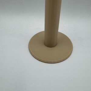 Op de afbeelding: Een beige, cilindrische standaard met een cirkelvormige basis. De standaard heeft een gladde, matte afwerking en staat tegen een witte achtergrond. De basis is een iets donkerdere tint beige dan de verticale steun.