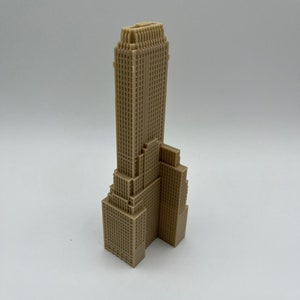 May include: A beige 3D printed model of a skyscraper with a detailed facade.