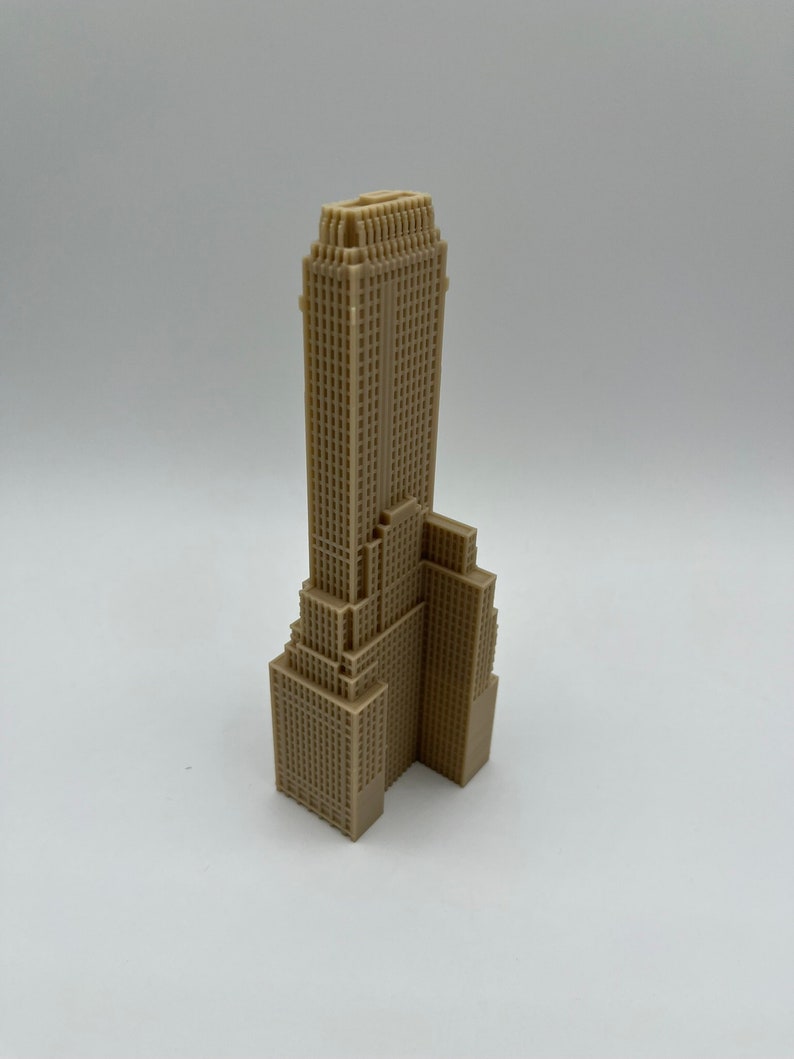 May include: A beige 3D printed model of a skyscraper with a detailed facade.