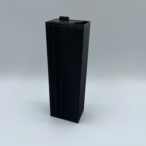 May include: A black miniature model of a skyscraper with a flat roof.