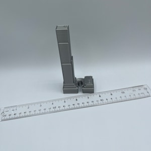 May include: A 3D printed model of a skyscraper, approximately 6 inches tall, with a ruler for scale.