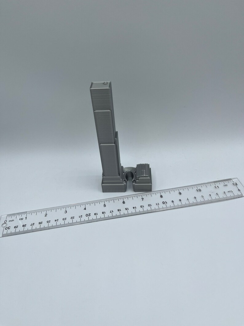 May include: A 3D printed model of a skyscraper, approximately 6 inches tall, with a ruler for scale.