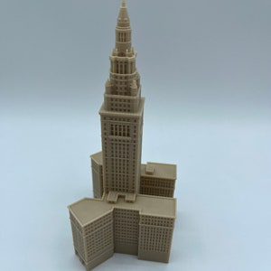 May include: A beige 3D printed model of the Terminal Tower in Cleveland, Ohio. The model is detailed and includes the tower's distinctive spire.