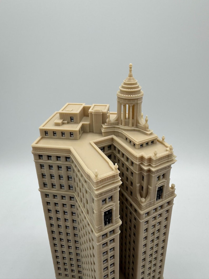 Op de afbeelding: Een beige 3D-geprint model van een hoog gebouw met een koepelvormig dak en veel ramen.