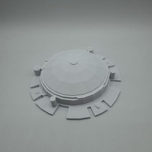 May include: A light gray, 3D-printed architectural model featuring a domed roof and a circular base with rectangular extensions. The model has a detailed, geometric design and is likely a miniature representation of a building or structure.