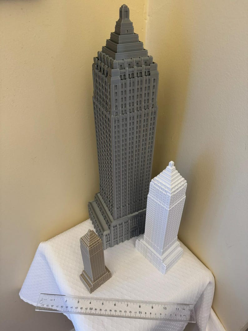 Puede incluir: Tres modelos de rascacielos impresos en 3D en diferentes tonos de gris. El edificio m&aacute;s alto es gris oscuro, el edificio del medio es gris claro y el edificio m&aacute;s peque&ntilde;o es gris marr&oacute;n.