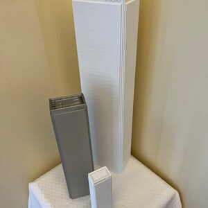 K&ouml;nnte beinhalten: Drei wei&szlig;e und graue 3D-gedruckte Modellgeb&auml;ude. Das h&ouml;chste Geb&auml;ude ist wei&szlig; und hat das Wort "ACW" obenauf gedruckt. Das mittlere Geb&auml;ude ist grau und das kleinste Geb&auml;ude ist wei&szlig;.