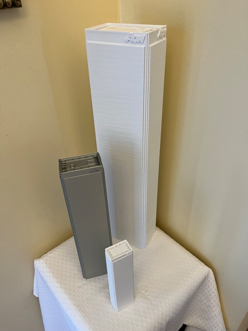 K&ouml;nnte beinhalten: Drei wei&szlig;e und graue 3D-gedruckte Modellgeb&auml;ude. Das h&ouml;chste Geb&auml;ude ist wei&szlig; und hat das Wort "ACW" obenauf gedruckt. Das mittlere Geb&auml;ude ist grau und das kleinste Geb&auml;ude ist wei&szlig;.
