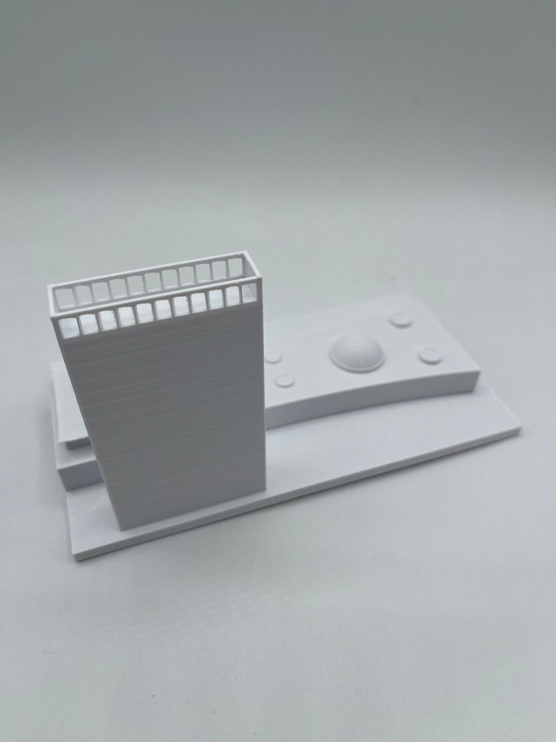K&ouml;nnte beinhalten: Ein wei&szlig;es 3D-gedrucktes Modell eines Geb&auml;udes mit einem Balkon und einem kuppelf&ouml;rmigen Dach. Das Modell steht auf einem wei&szlig;en Sockel.