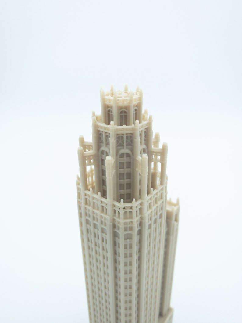May include: A detailed 3D printed model of a tall building with a decorative top and many windows.