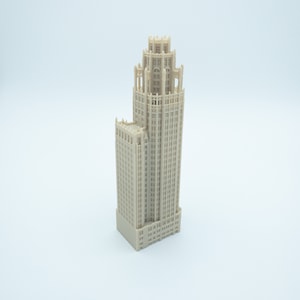 May include: A beige miniature model of a tall, ornate building with a detailed facade and multiple windows.