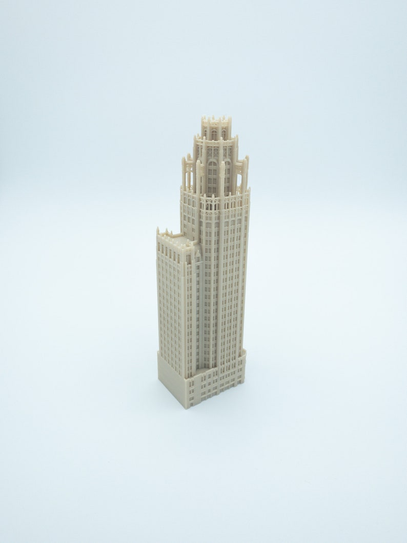 May include: A beige miniature model of a tall, ornate building with a detailed facade and multiple windows.