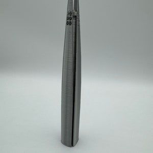 May include: A 3D printed model of a skyscraper, made of gray plastic. The model is detailed with windows and a textured surface.