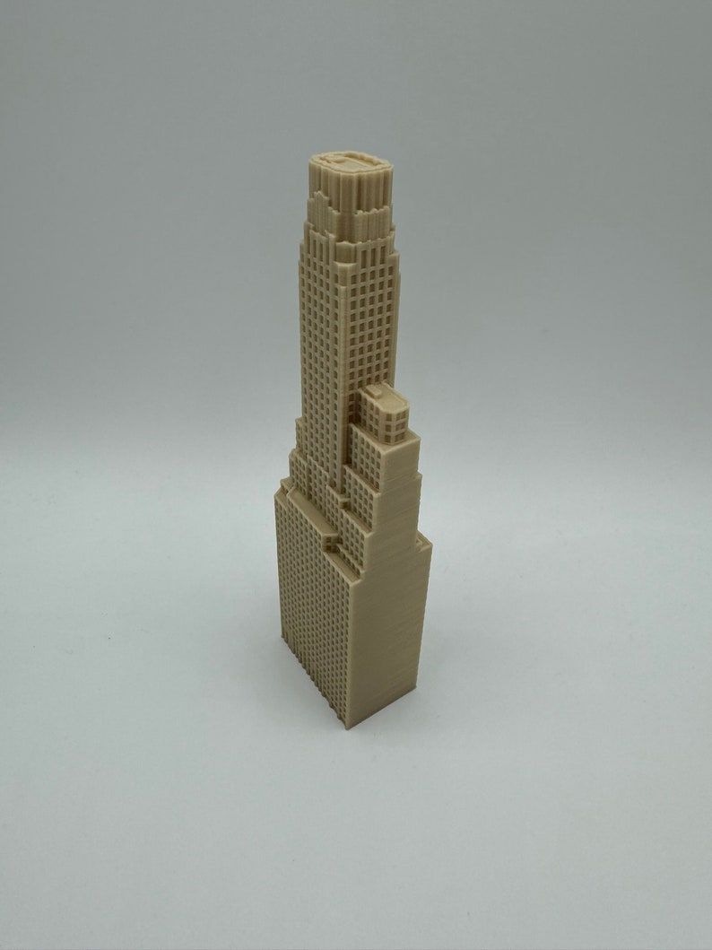May include: A beige 3D printed model of a skyscraper with a flat roof and many windows.