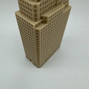 May include: A beige 3D printed model of a skyscraper with a detailed facade.