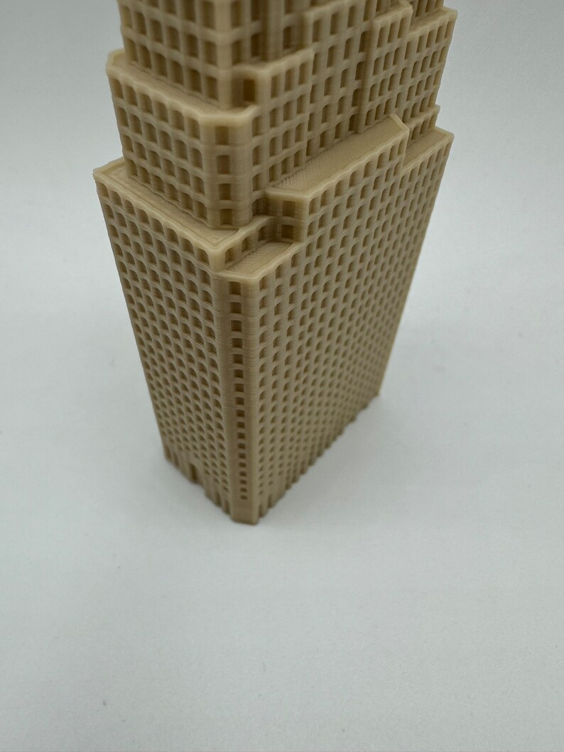 May include: A beige 3D printed model of a skyscraper with a detailed facade.