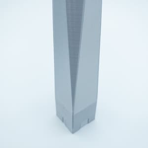 May include: A close-up of a gray, 3D printed model of a skyscraper. The model is detailed and has a sharp, angular design.