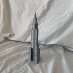 Puede incluir: Un modelo gris del edificio Chrysler, un famoso rascacielos en la ciudad de Nueva York. El modelo es detallado e incluye la ic&oacute;nica aguja del edificio.