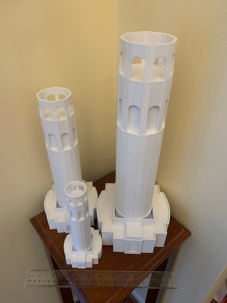 Może przedstawiać: Trzy białe modele Golden Gate Bridge, ikonicznego pomnika San Francisco, wydrukowane w 3D. Modele są w r&oacute;żnych rozmiarach, a największy ma około 30 cm wysokości.
