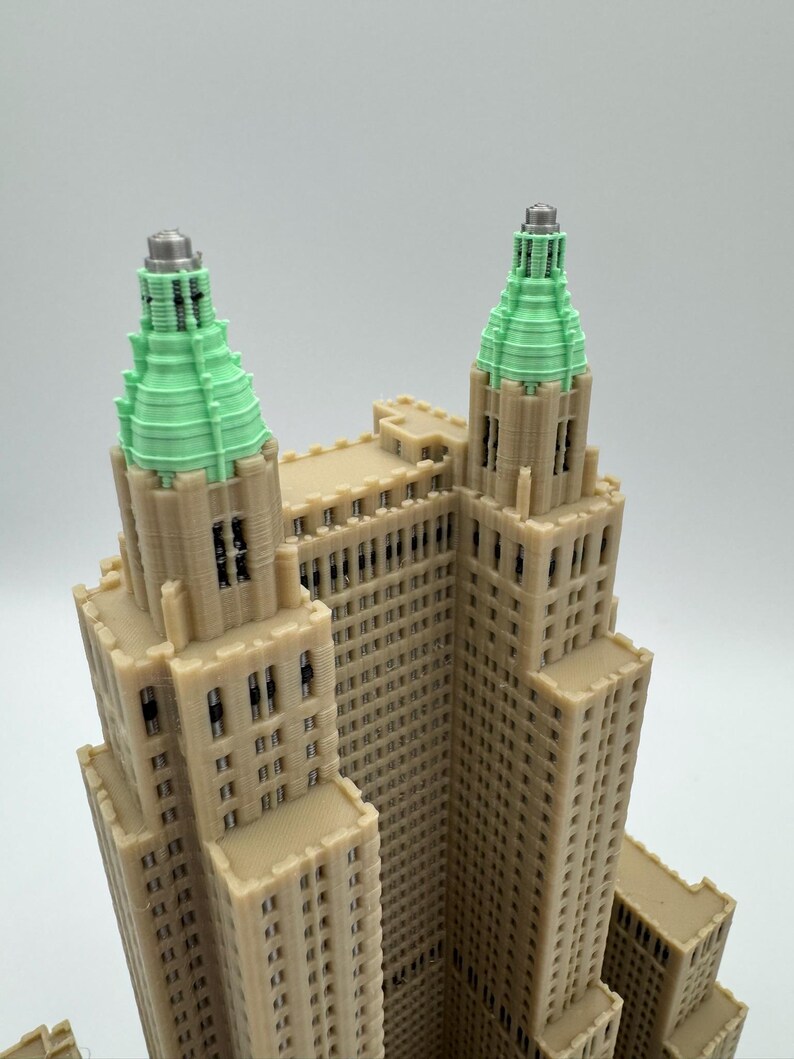 Może przedstawiać: Szczeg&oacute;łowy model 3D budynku z beżową fasadą i wieżami z zielonymi szczytami. Model prezentuje detale architektoniczne, w tym okna i elementy dekoracyjne, na neutralnym tle.
