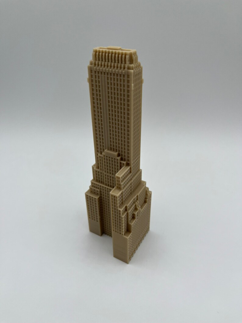 May include: A beige 3D printed model of a skyscraper building.