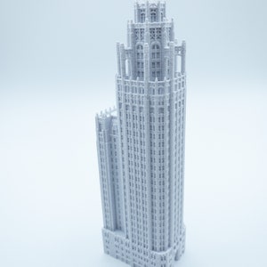 May include: A white 3D printed model of a tall, ornate building with a pointed roof and many windows.