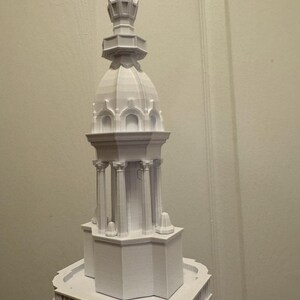 Op de afbeelding: Een wit 3D-geprint model van een gebouw met een gedetailleerde koepel en toren.