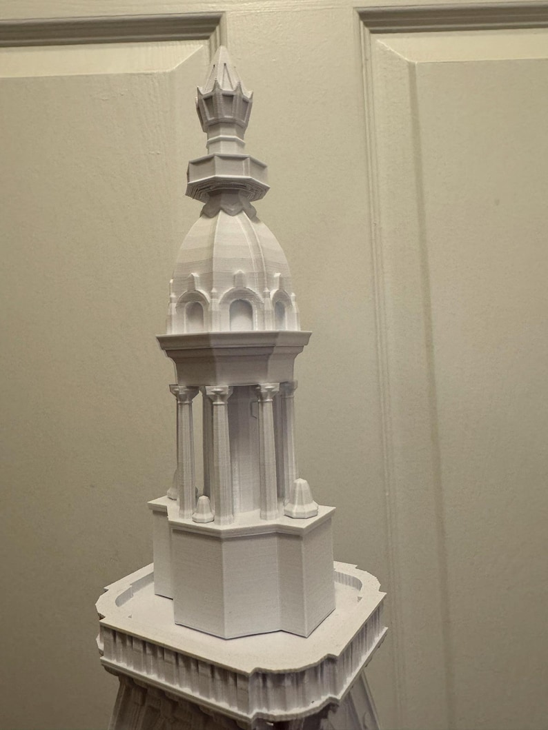 Op de afbeelding: Een wit 3D-geprint model van een gebouw met een gedetailleerde koepel en toren.
