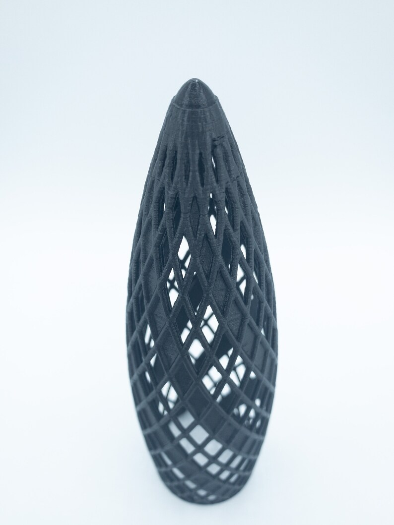 May include: A black, 3D printed, geometric, cone-shaped object with a lattice design.