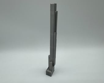 May include: A grey 3D printed model of a tall skyscraper building.