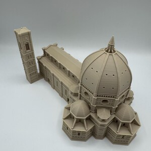 May include: A beige 3D-printed model of the Florence Cathedral, featuring the iconic dome, bell tower, and architectural details. The model showcases the building's intricate design and structure.